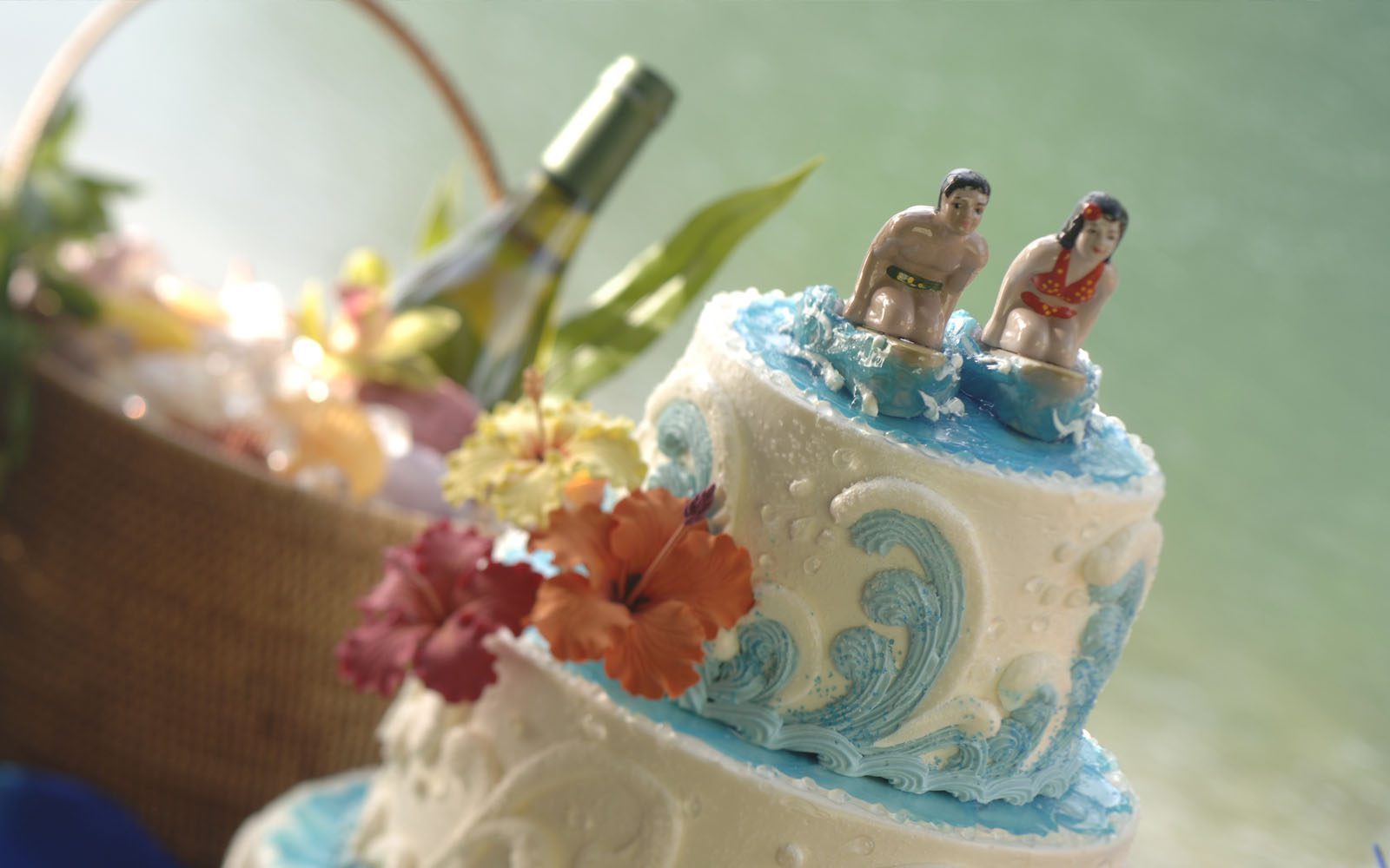 Vintage surfing inspired wedding cake with a salt and pepper vintage surfing couple on the top of a white and blue wave cake