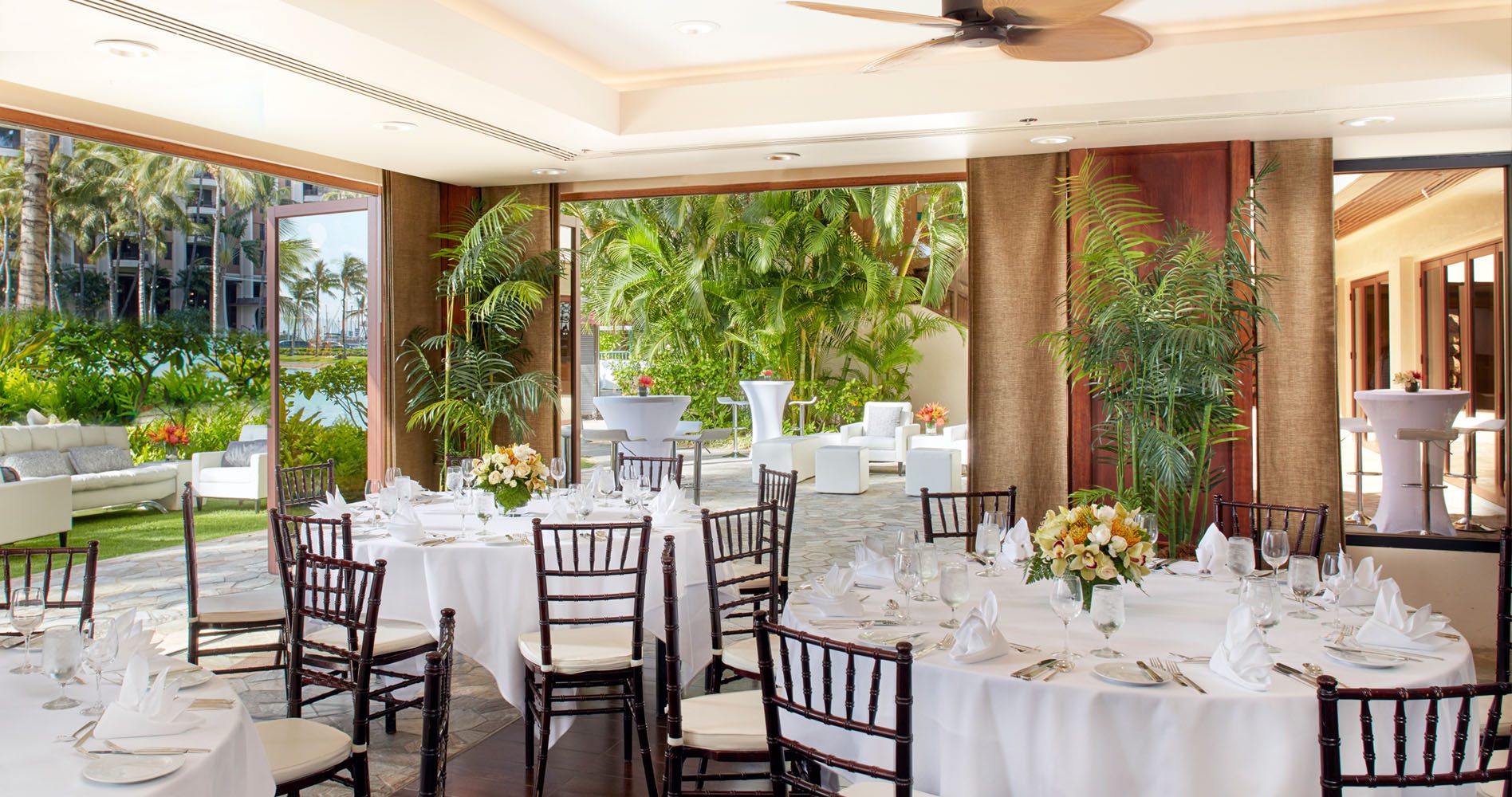 Interior of the Rainbow Suite banquet room set up for an event with doors to the patio open to the beautiful scenery.