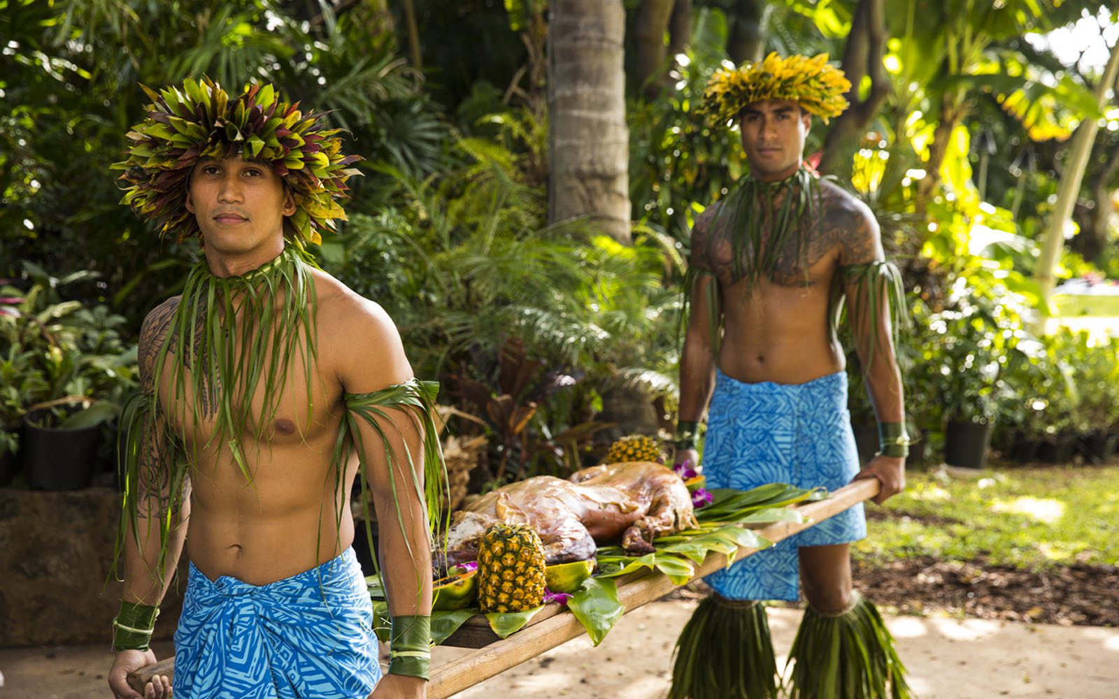 Waikiki Starlight Luau dancers carrying the pig for the parading of the pig at the luau.
